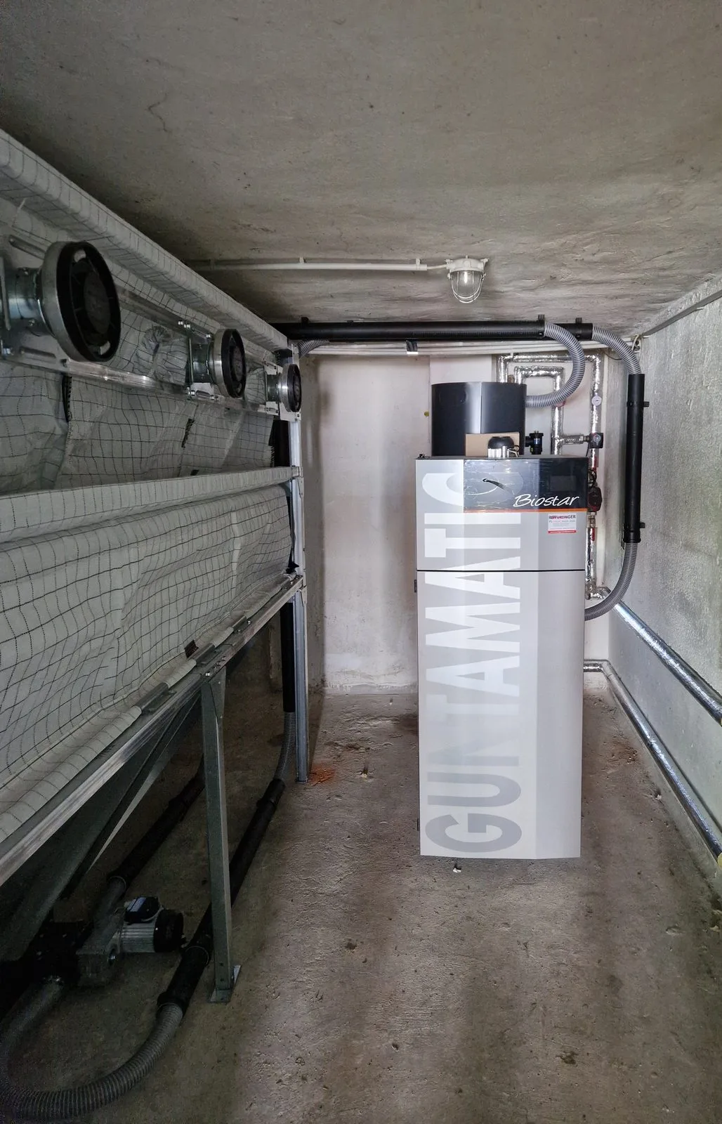 Guntamatic Biostar Pelletskessel neben Gewebetank-Lagerbox