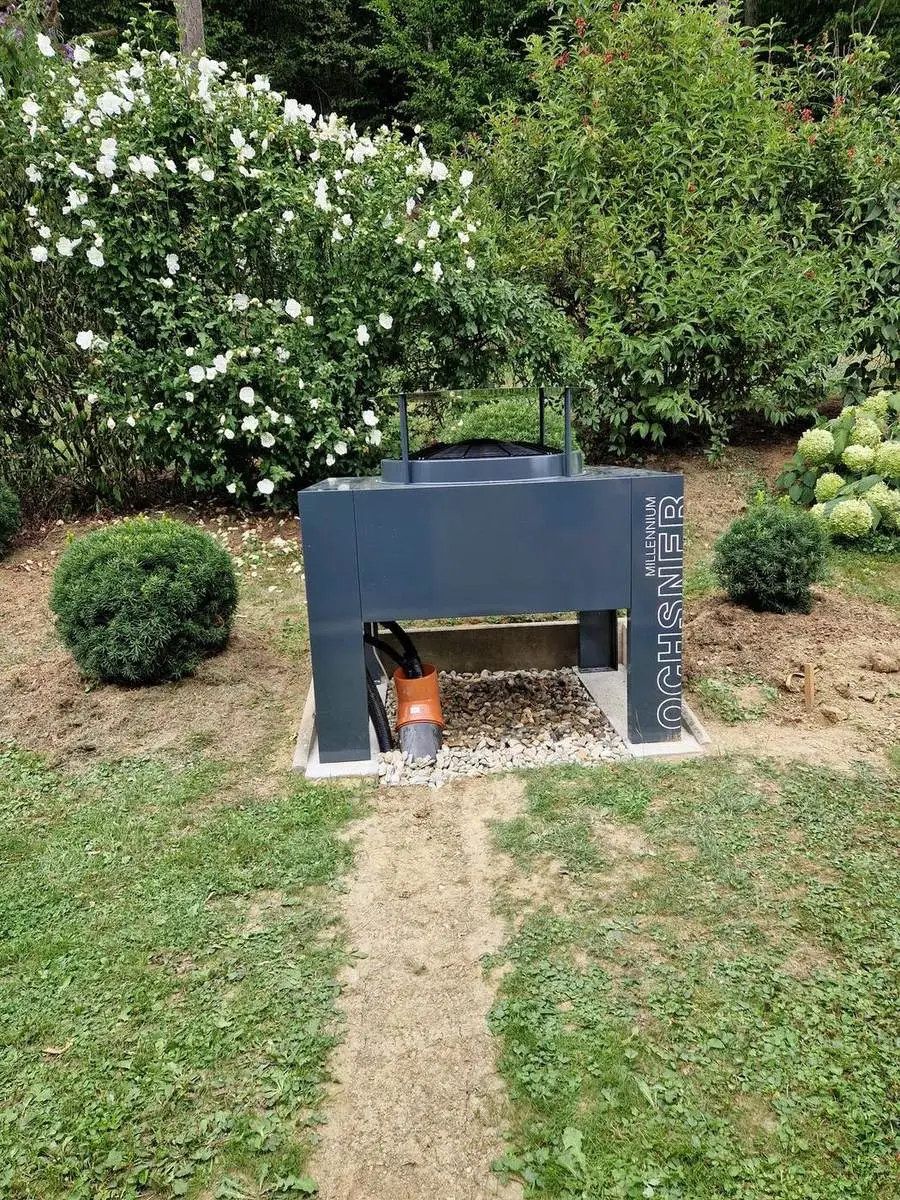 Ochsner Luftwärmepumpe Außengerät auf Kiesbett im Garten